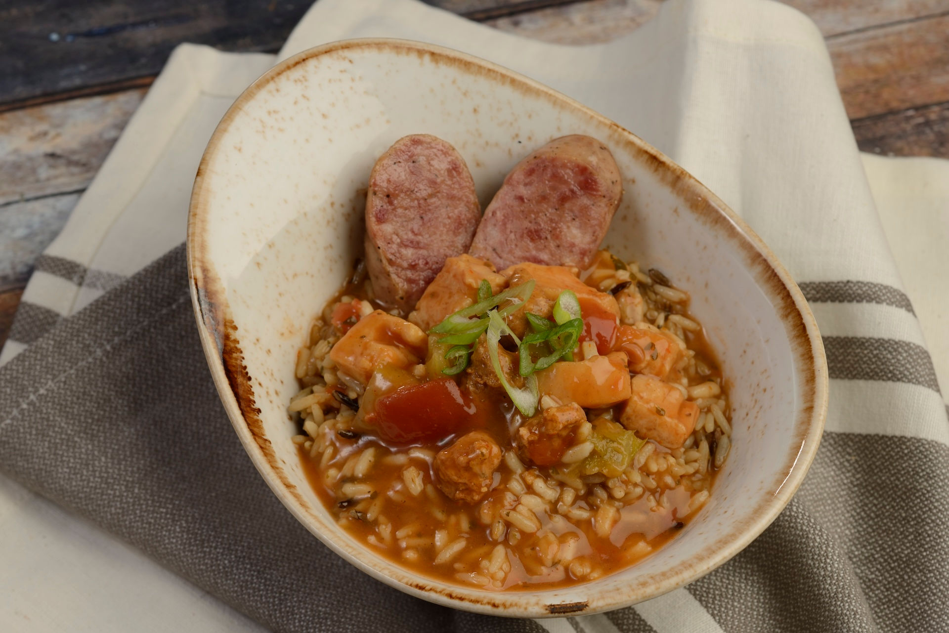 Hearty sausage and vegetable stew served over grains at EPCOT International Flower & Garden Festival Outdoor Kitchen, featuring savory Disney World festival comfort food and globally inspired tasting portions.
