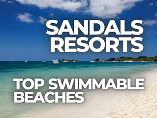 Beachfront promotional graphic for Sandals Resorts highlighting top swimmable beaches in the Caribbean. The image shows a calm turquoise ocean, soft white sand shoreline, and anchored boats under a bright blue sky with scattered clouds. Large overlay text reads “Sandals Resorts – Top Swimmable Beaches,” emphasizing luxury all-inclusive beach vacations ideal for swimming, relaxation, and romantic getaways.