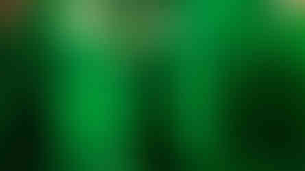 Halloween Horror Nights performer in a dark robe casting a spell in a green-lit alley, creating a mystical and eerie atmosphere. Death Eaters from Harry Potter