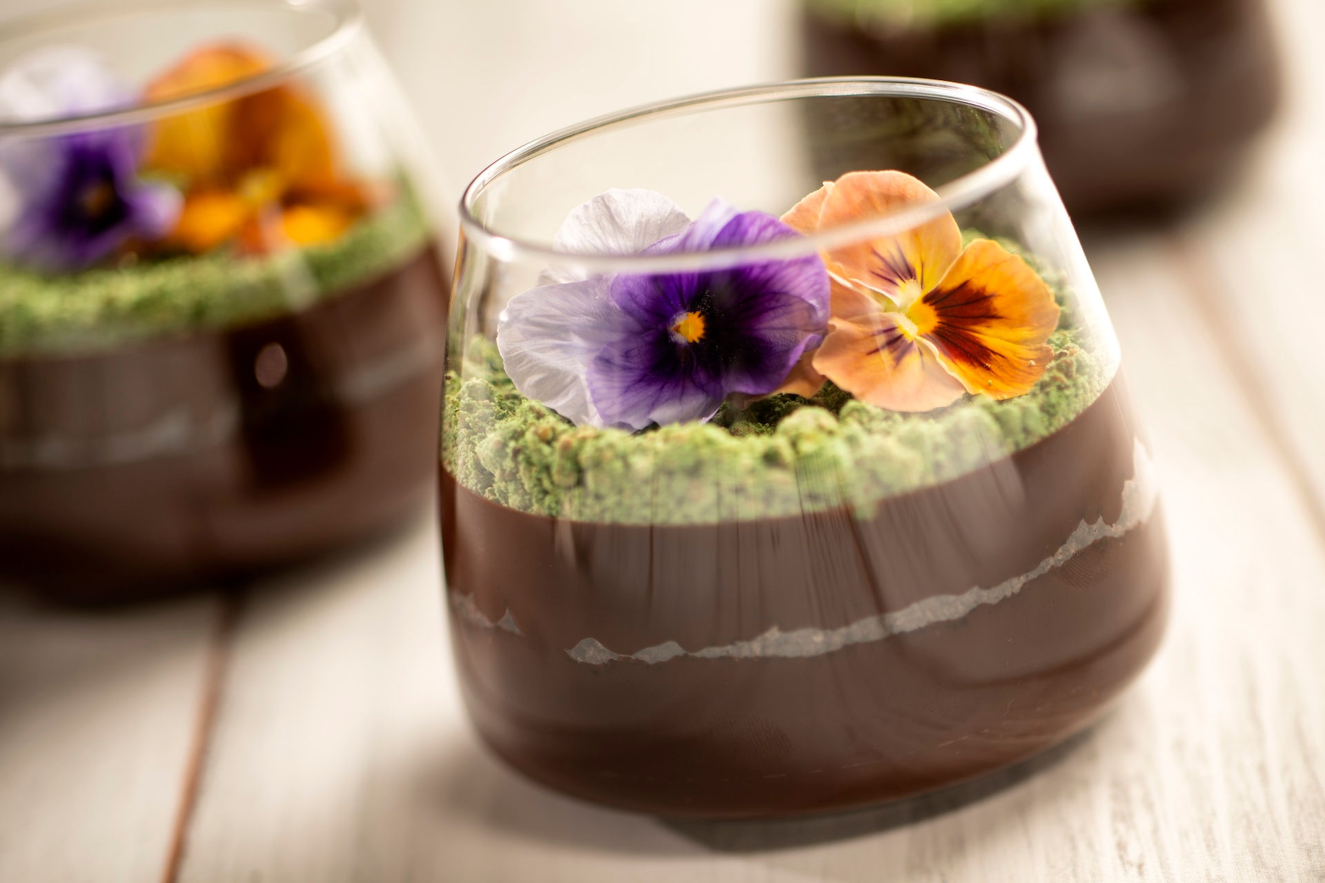 “Chocolate mousse terrarium dessert with matcha crumb and edible flowers at EPCOT Flower and Garden Festival, an Instagram-worthy Walt Disney World festival treat featured in Disney vacation planning recommendations by Brandi Parker.”