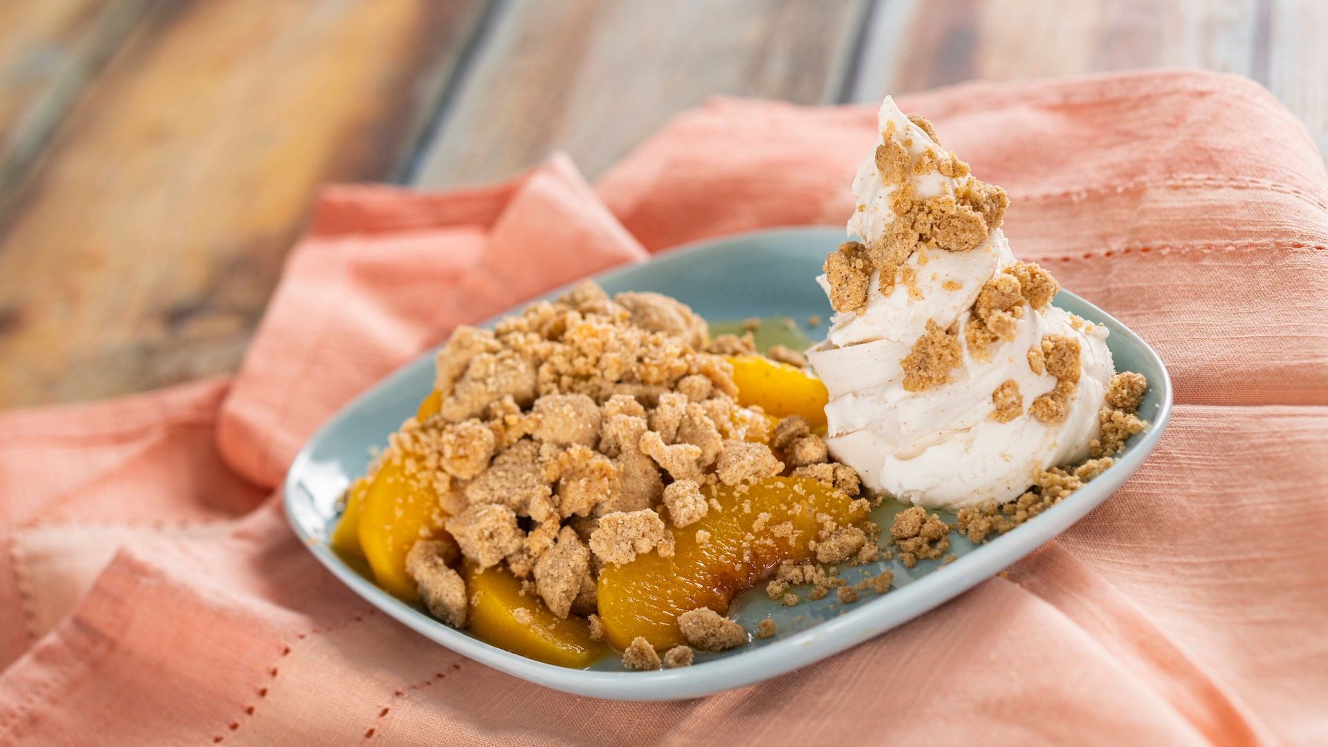 Peach cobbler topped with cinnamon gelato and crumble from EPCOT International Flower & Garden Festival Outdoor Kitchen at Walt Disney World, showcasing must-try festival desserts and expert Disney trip planning insights from vacation planner Brandi Parker.