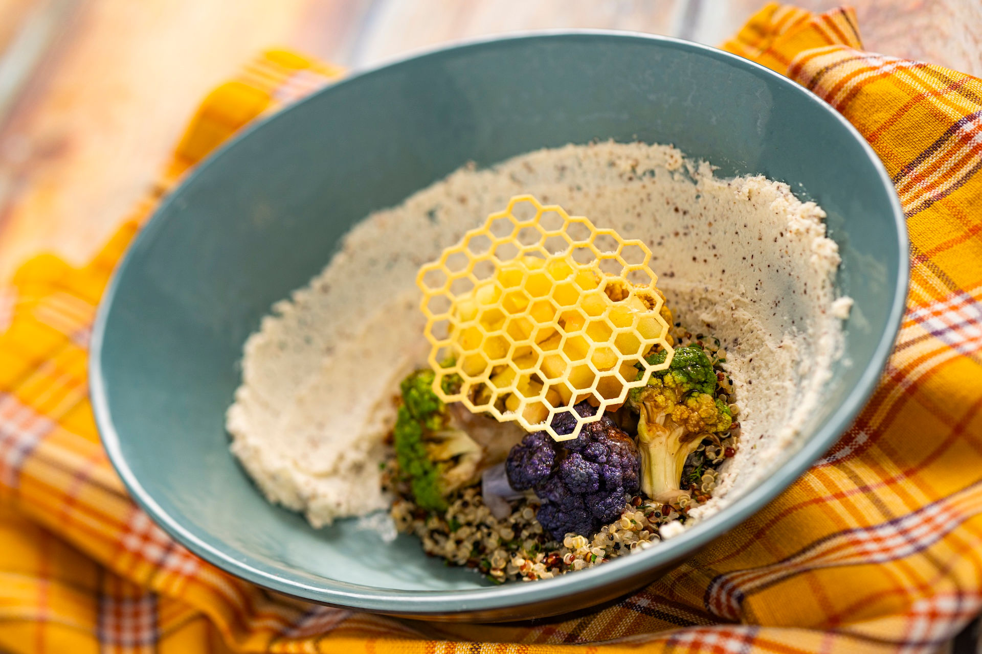 “Artfully plated EPCOT Flower and Garden Festival dish featuring vegetables, grains, and decorative honeycomb garnish at Walt Disney World Outdoor Kitchen, highlighting festival dining experiences curated with guidance from Disney travel advisor Brandi Parker.”