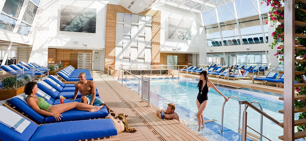 Guests relaxing at the indoor solarium pool on a Celebrity Cruises ship, featuring a bright glass-covered pool deck with lounge chairs and adults enjoying a relaxing spa-like cruise experience.