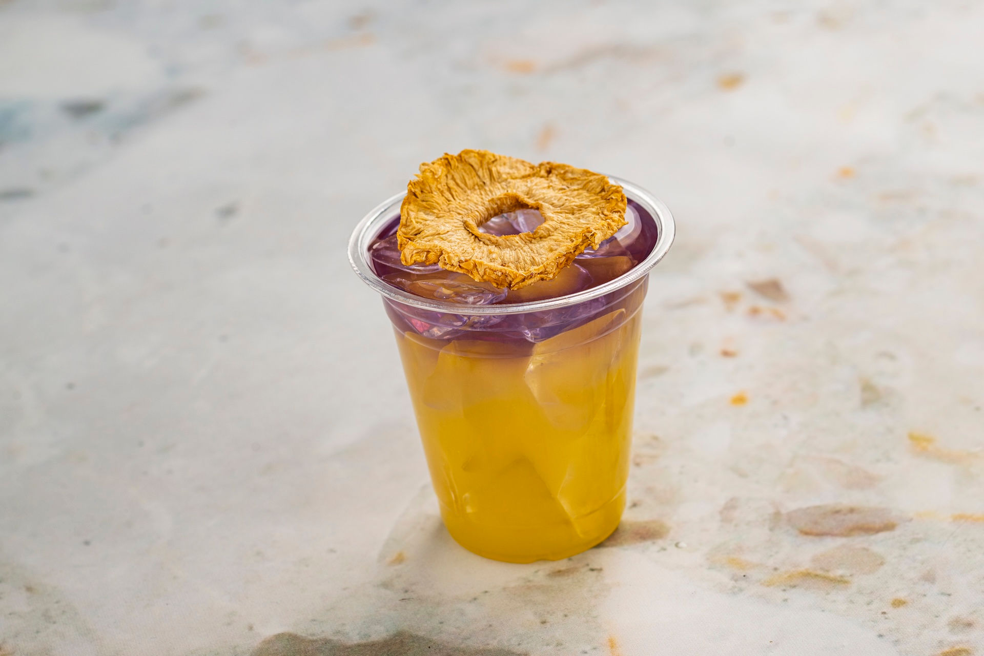 Tropical pineapple festival drink with garnish at EPCOT Flower and Garden Festival Outdoor Kitchens, representing refreshing Disney festival beverages and smart snack planning guidance from Brandi Parker, experienced Walt Disney World travel advisor