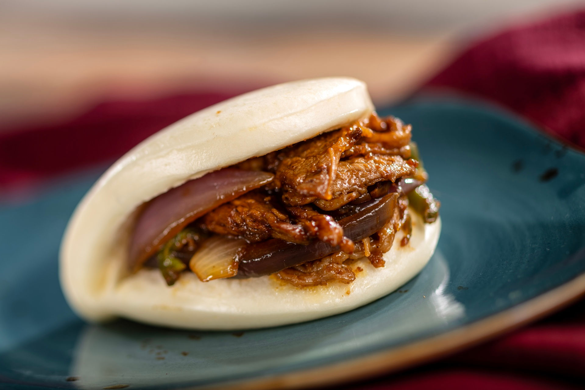Pulled pork bao bun with vegetables and sauce from EPCOT Flower & Garden Festival food booth in Walt Disney World.