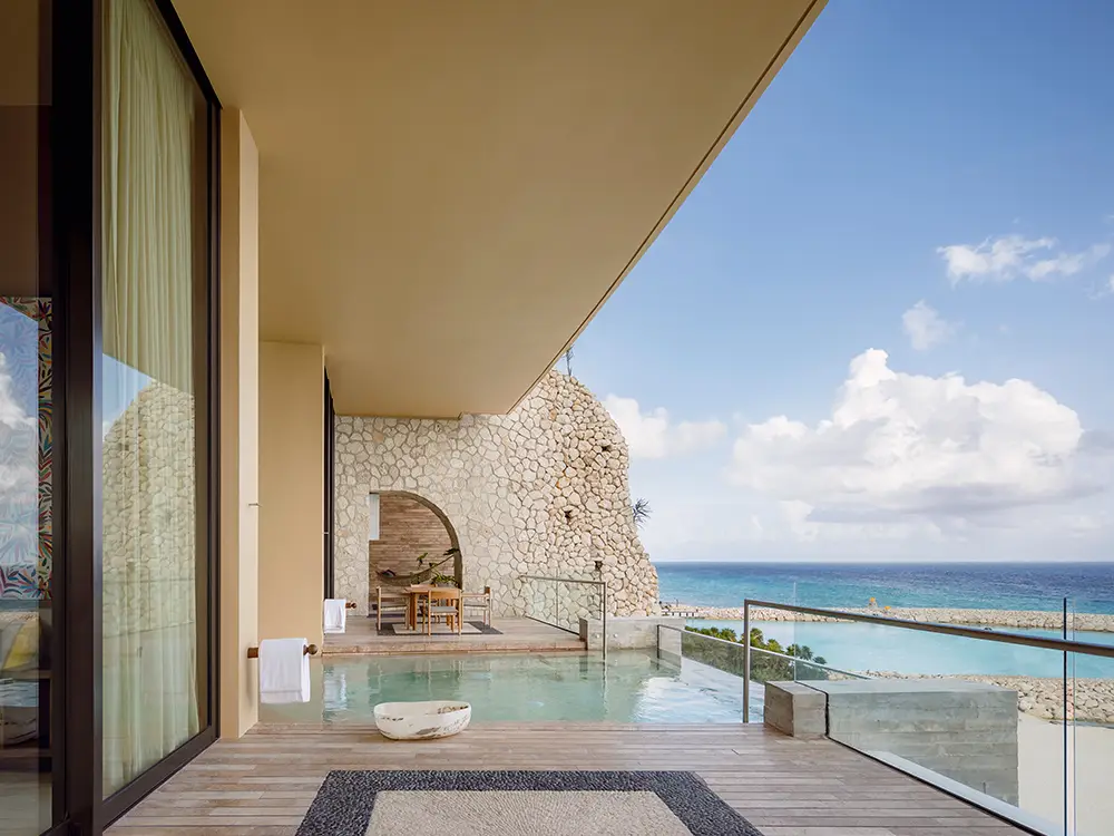 Oceanview terrace suite at La Casa de la Playa featuring private pool, stone architecture, and sweeping Caribbean Sea views, highlighting exclusive adults-only luxury and personalized resort experience.