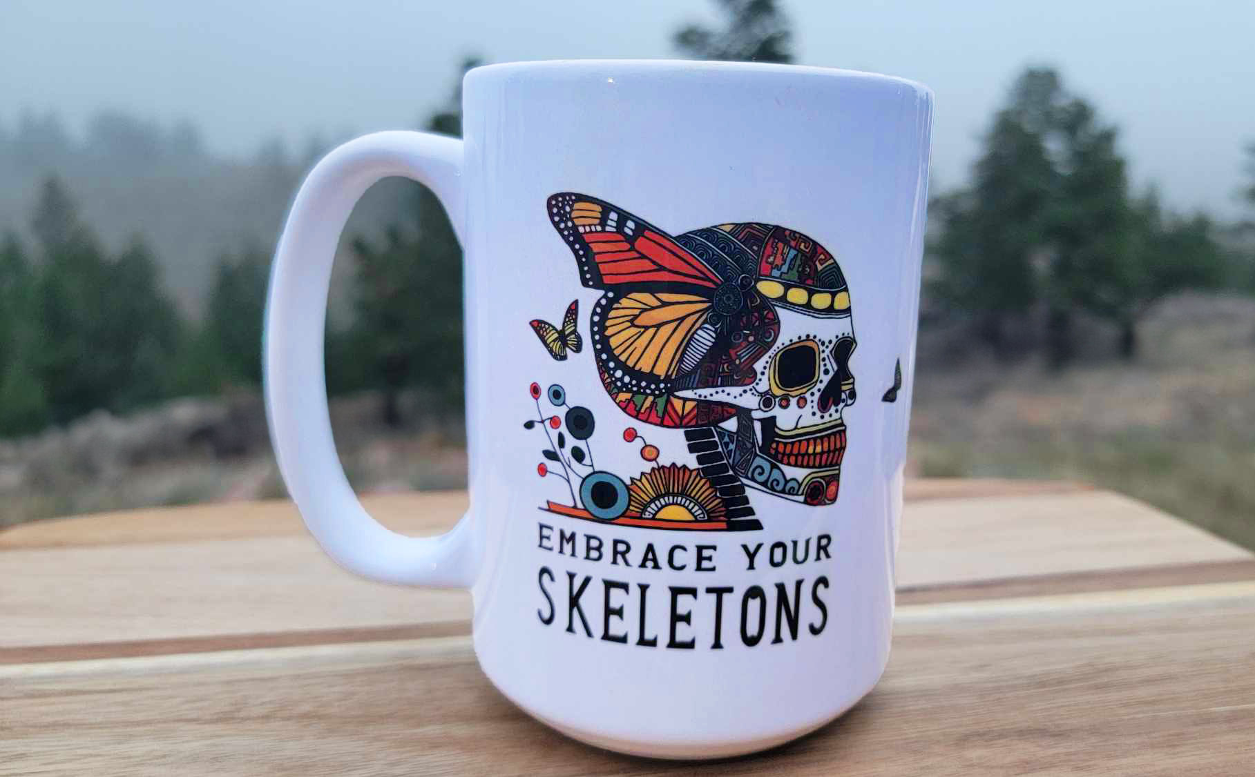 A large 15 oz white mug with a dia de los muertos skeleton sugar skull on it.