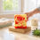 Thumbnail: A vibrant, artisan Strawberry soap bar, marbled in swirls of red and yellow, rests elegantly on a rustic wooden soap dish