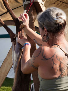 Theresa Emmerich Kamper processinganimal hide outdoors.