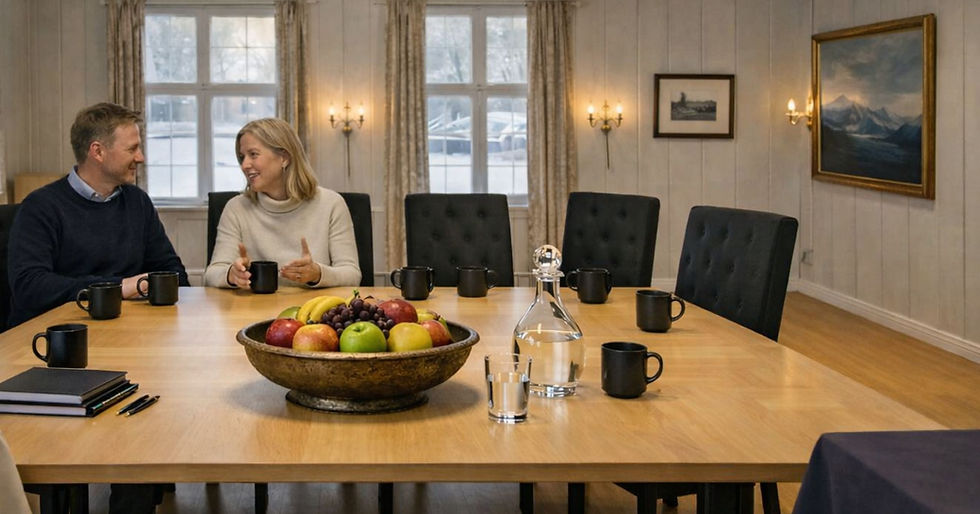 Two people in a meeting room with fruit and coffee.