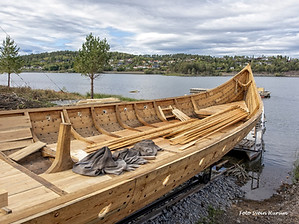The Queen Asta Viking ship replica resting in a Norwegian fjord on a cloudy day.