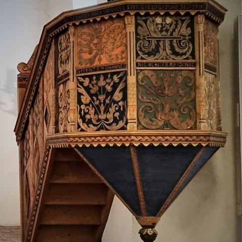 This pulpit is a true work of with painted and carved flowers and symbols. Latin words rund along the middle of the pulpit.