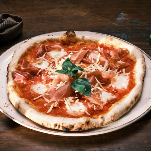 Fersk pizza med skinke, ost og basilikum