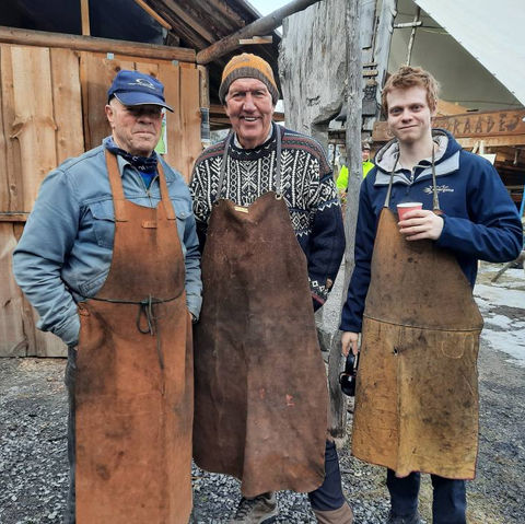 Tre smeder står foran smia til Hardraade vikingskipforening.