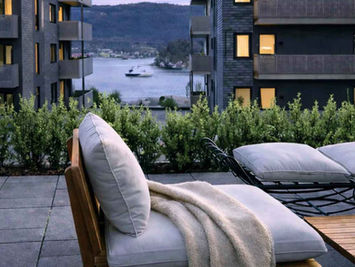 Takterrasse med utemøbler og utsikt mot sjøen