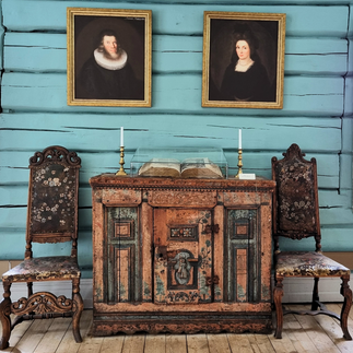 Portraits from the early 18th century of Anna Colbjørnsdatter and her husband Jonas. They are dressed in black clothes and both of them has head attire.