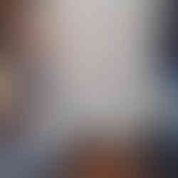 Hands holding tanned deer hide, surrounded by white paper. DEER SKIN TANNING