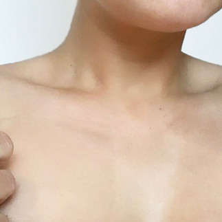 Women holding sheer fabric swatch against her skin.