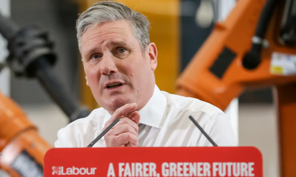 Kier Starmer giving a speech in front of a Labour podium reading A fairer, Greener Future