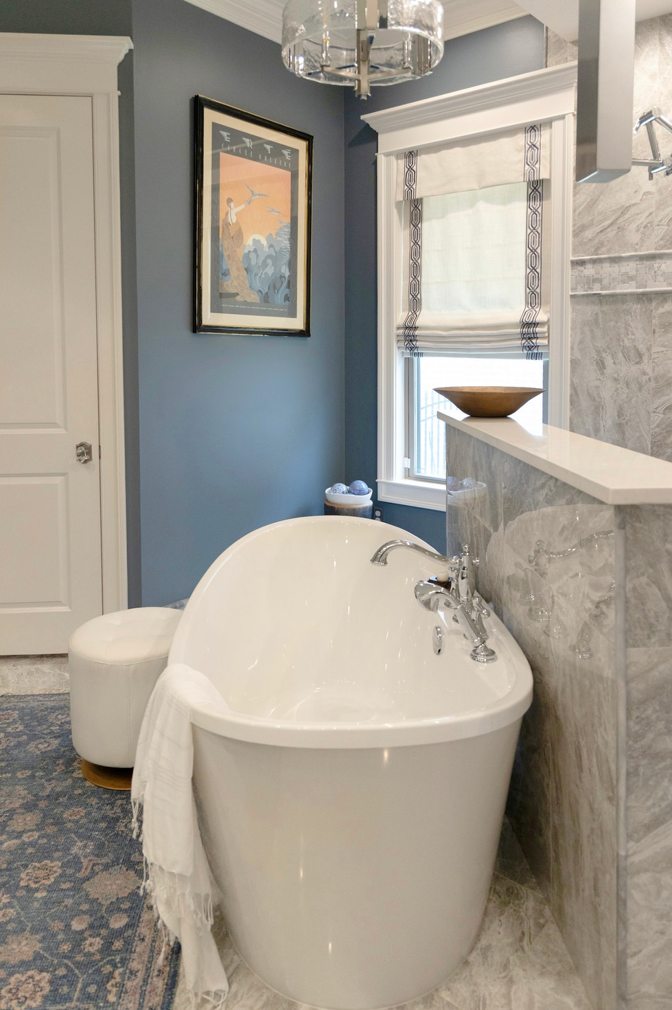 a bathtub in a bathroom with a picture on the wall above it