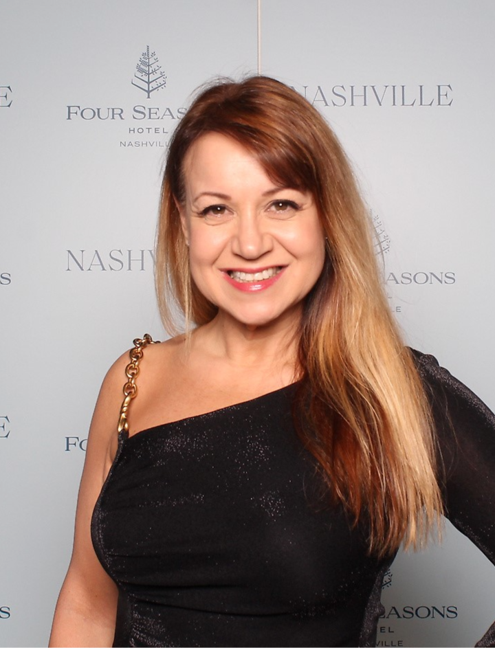 Cathryn Marshall in a black dress in front of a Four Seasons Nashville backdrop