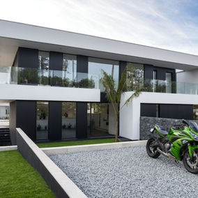 Modern house, white render, black composite panels,  green motorcycle