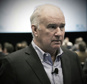 A close-up portrait of a professional economist, showcasing a thoughtful expression.