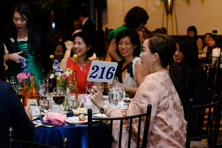 woman holding sign auctioning bidding on an item