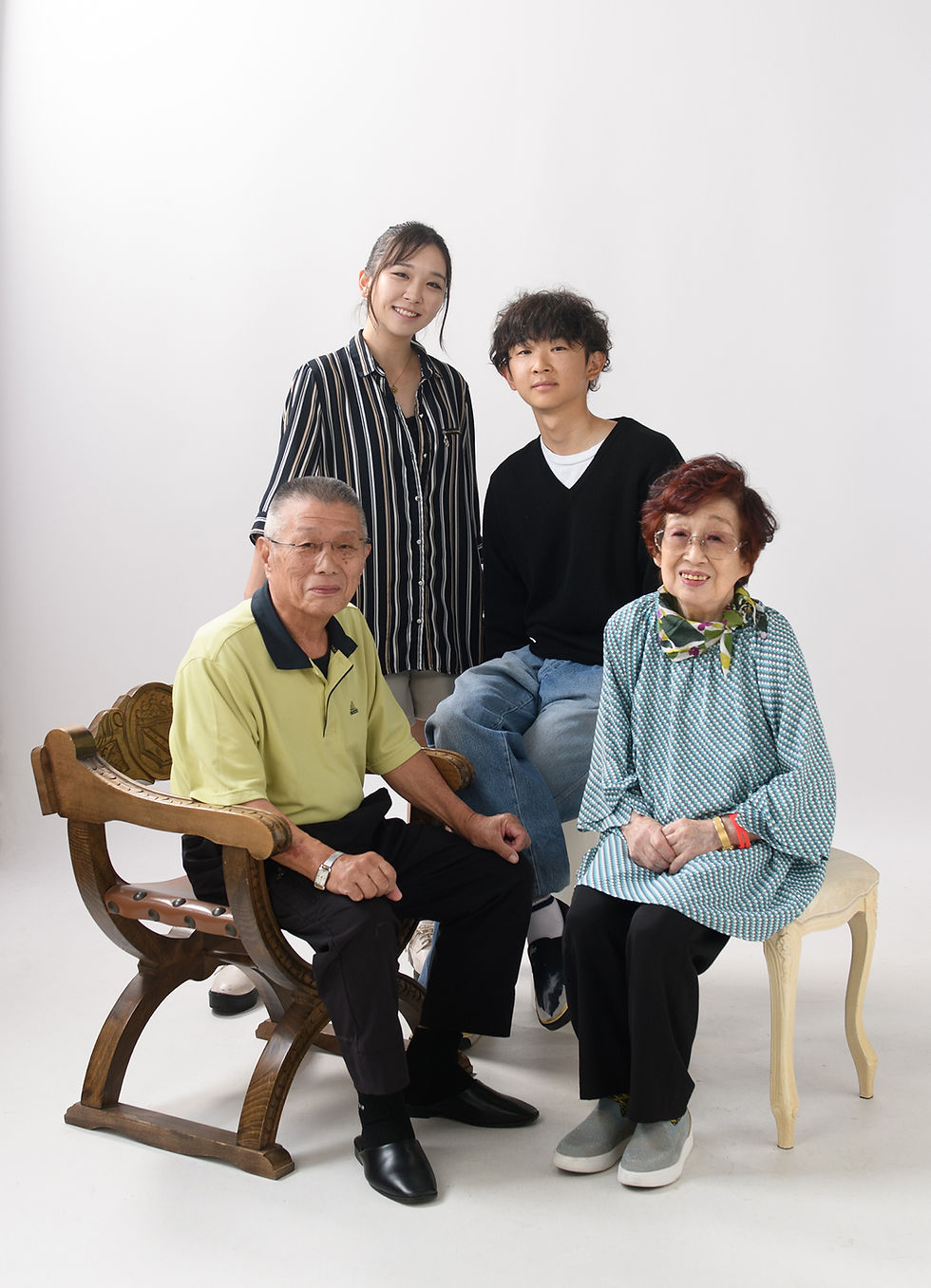笑顔で並ぶシニア夫婦と孫の家族肖像写真