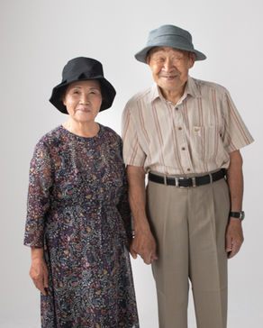 帽子を被り笑顔で並ぶシニア夫婦の肖像写真