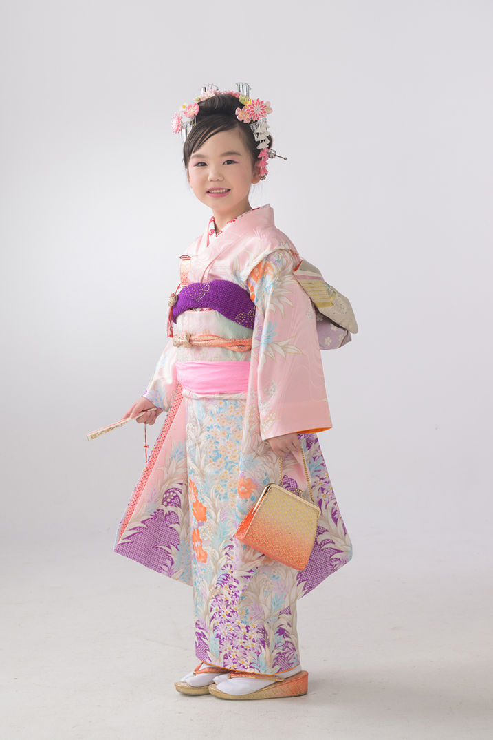 華やかな着物姿で微笑む七五三の女の子