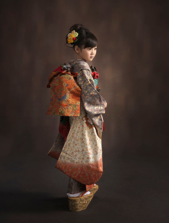 華やかな着物姿でポーズをとる七五三の女の子