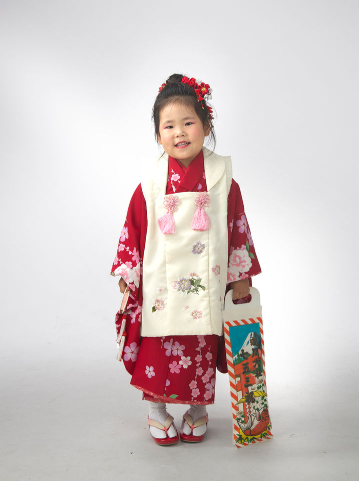 千歳飴を持って赤い着物を着た三歳の女の子の七五三