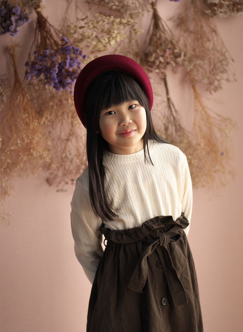 赤いベレー帽を被って微笑むキッズモデルの女の子