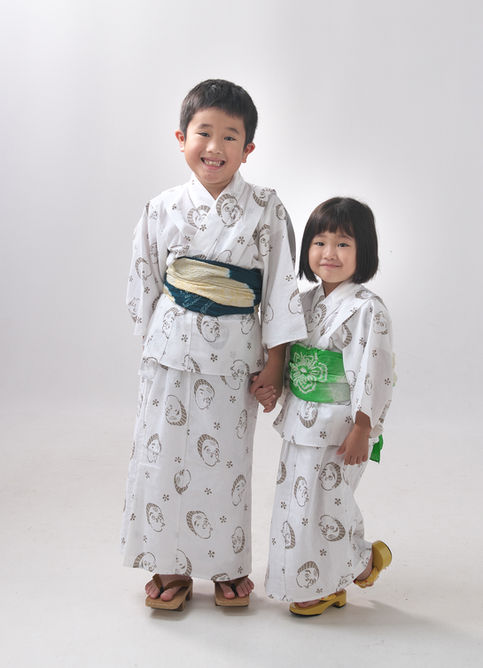 お揃いの浴衣を着て手をつなぐ笑顔の男の子と女の子