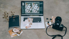  A professional stock photographer reviewing photos on a laptop with camera gear beside.