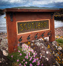 A wooden coatrack set against a coastal landscape.
