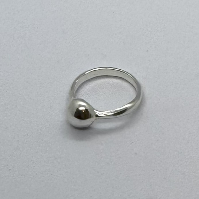 Thumbnail: Silver ring with a rounded ball, shown from a side angle