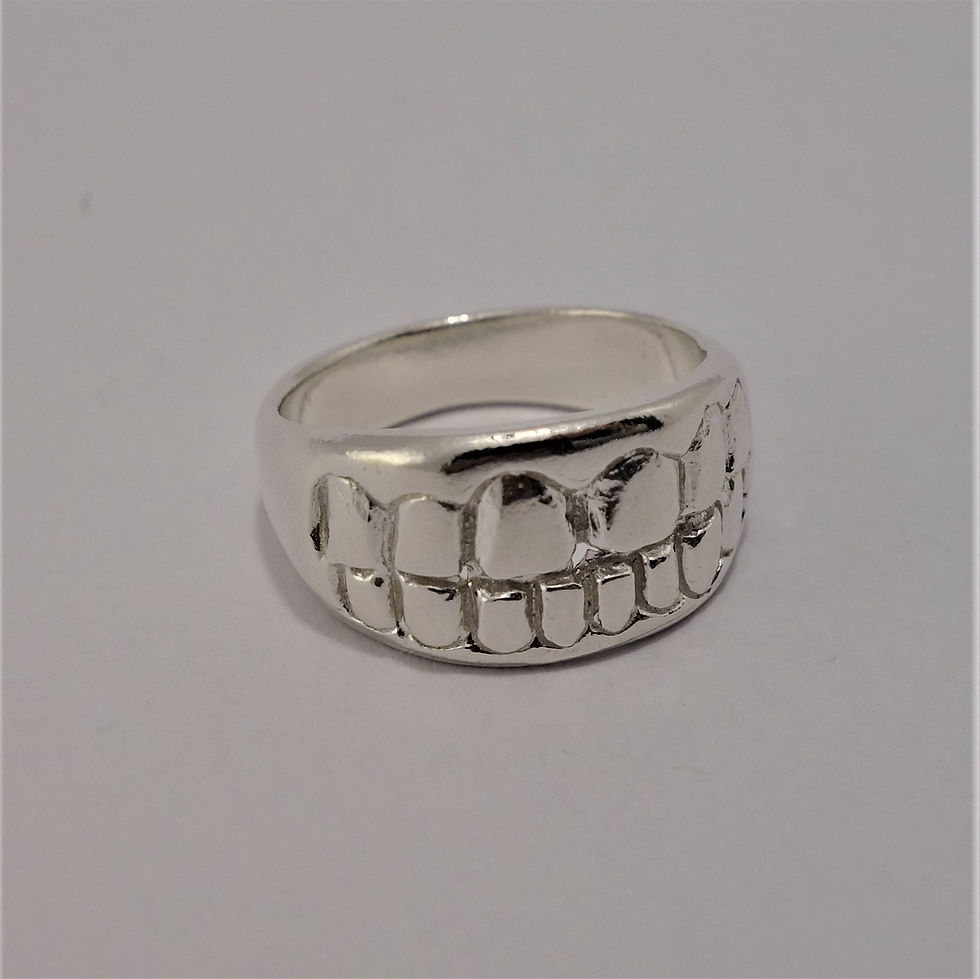 Thumbnail: Bold silver ring with a sculpted design of human teeth across the front, displayed on a white background