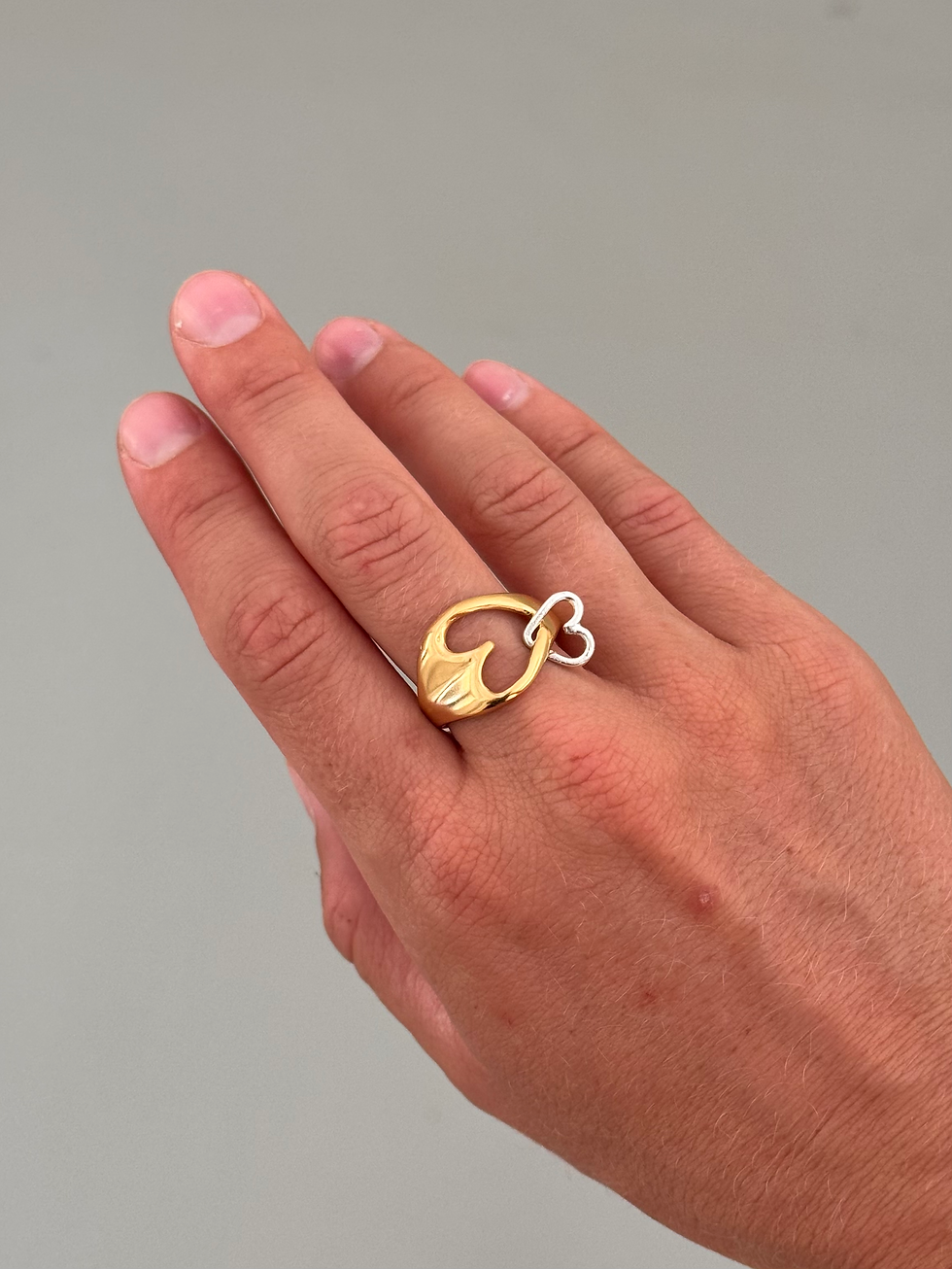 Thumbnail: Gold-plated  heart ring with a small silver heart looped through a larger one on a hand