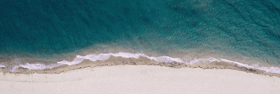 Das Bild zeigt eine Luftaufnahme eines klaren Meeres und seine Wellen, das sanft auf einen wunderschönen weißen Sandstrand trifft. Es handelt sich um die website von dr izlem alptekin online-coaching und mentaltraining
