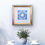 Thumbnail: Framed Hebrew Home Blessing for Sons with Interwoven Branches artwork, hung above a pot plant and teacups on a table.