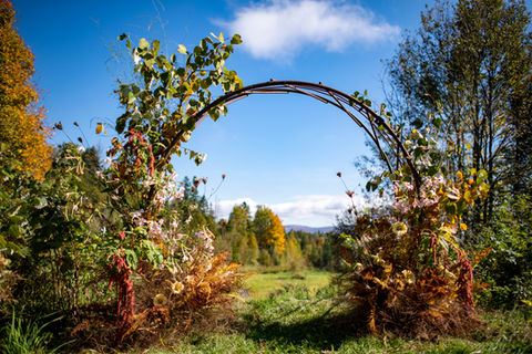 fall circular wedding arch with foliage and ferns in brown tones