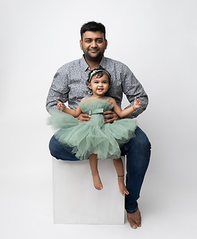 Father lifting baby up high during family portrait session in London