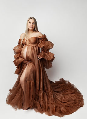 Full body maternity photoshoot in London studio with elegant standing pose