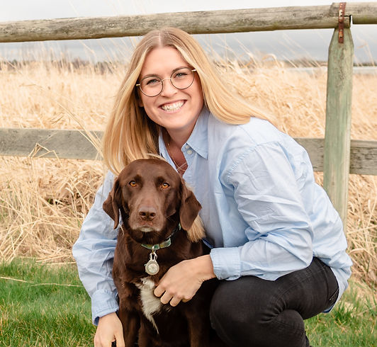 Blonde professional woman outside with brown dog
