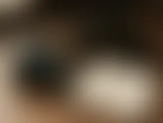木質桌面上有一台單眼相機與幾顆鏡頭,另外有一本上面記載攝影知識的筆記本