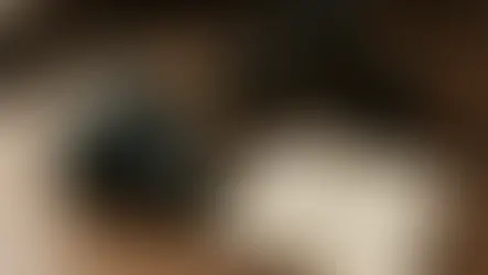 木質桌面上有一台單眼相機與幾顆鏡頭，另外有一本上面記載攝影知識的筆記本