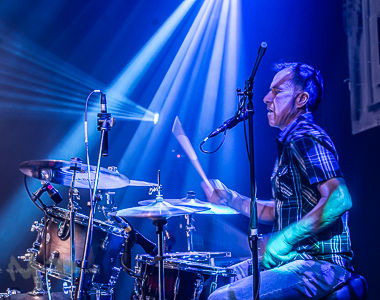 Drummer playing under stage lights