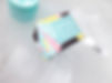 Glacial Glow facial care to exfoliate, detox, balance, in bright multicoloured box with blue, yellow and pink pattern next to tub and applicator brush surrounded by ice, design by Organic Lines Design Studio.